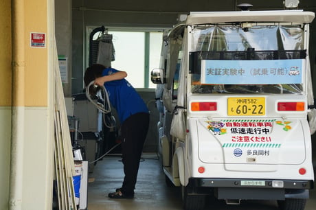 自動運転カートの点検を行う住民(東海クラリオン)